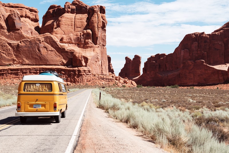 An open road curving through rolling hills toward distant mountains under a wide sky